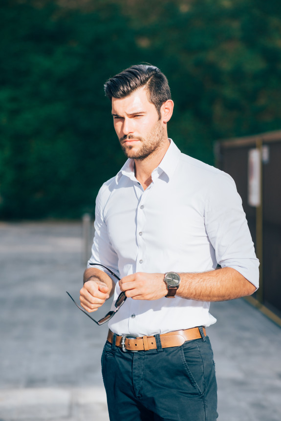 Knee figure of young handsome caucasian black hair modern businessman posing in the city, overlooking right, serious - working, business, successful concept